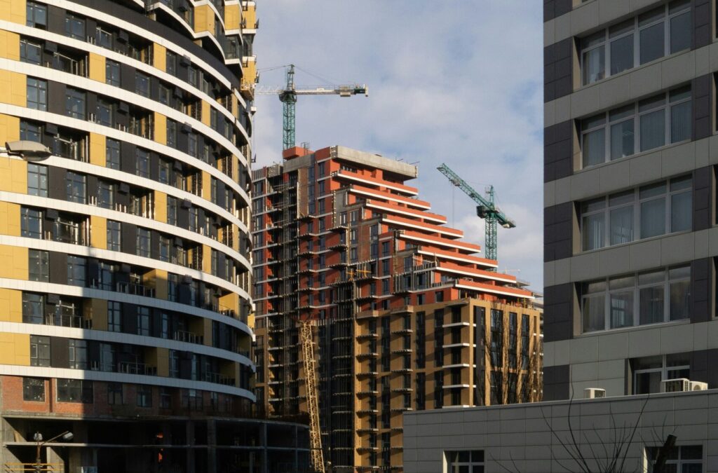 Fastigheter och nybyggnation med lyftkranar i bakgrunden.